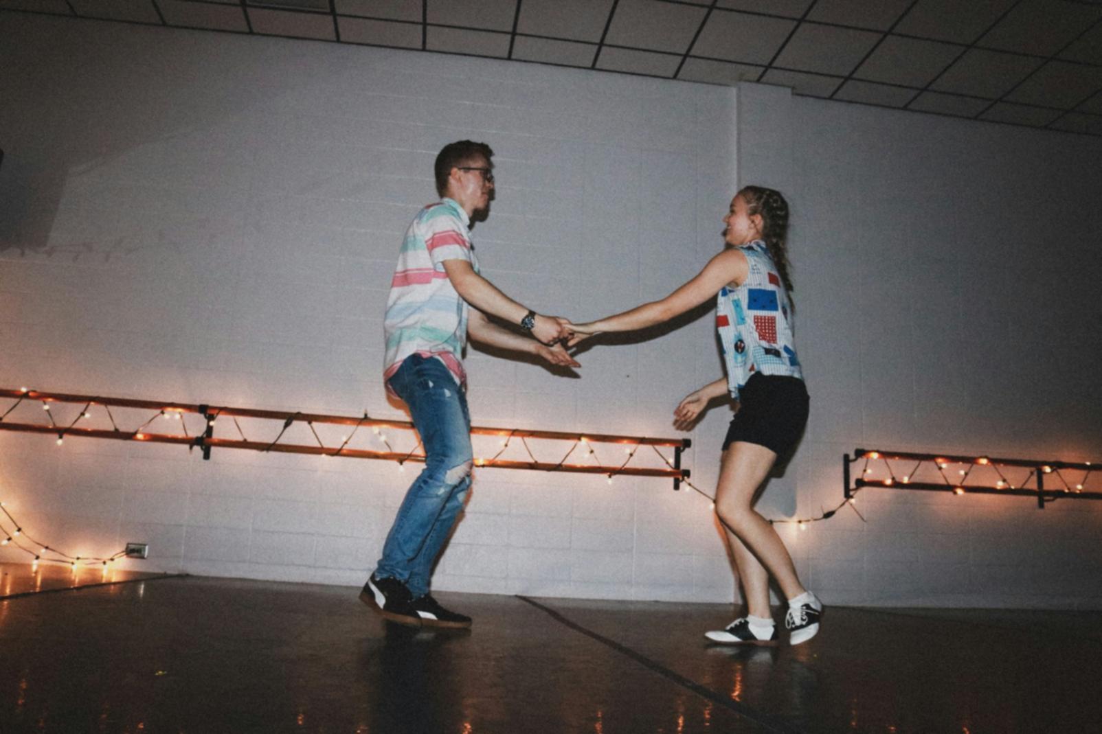 Instructor demonstrating dance technique to attentive student